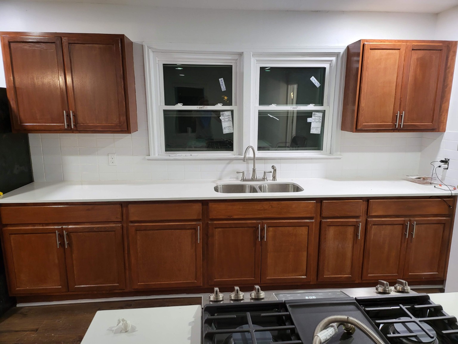 Wide view of the wood cabinetry, windows, and sink wall